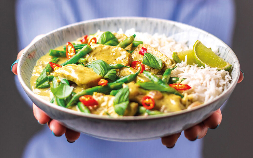 Hands holding pork rice bowl