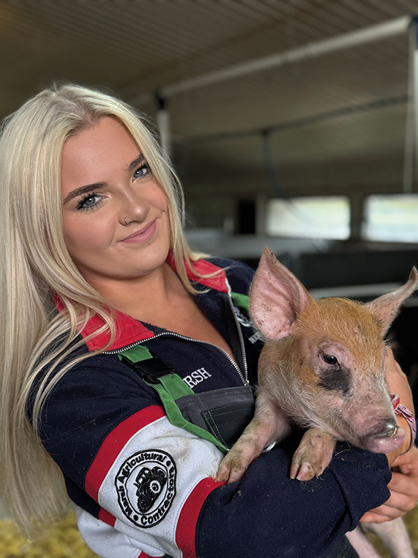 Esme Marsh holding a piglet