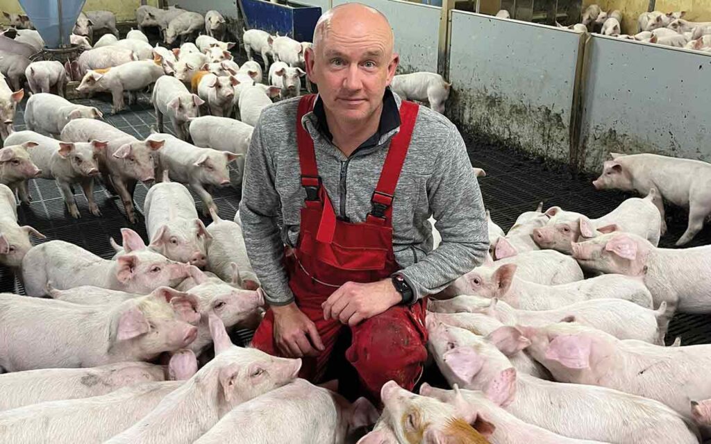 Gregor Christie kneeling with pigs